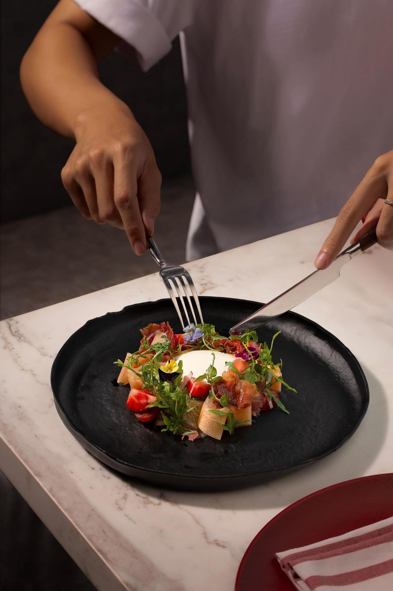 Melia Vinpearl Hue Hotel Luaran gambar A salad being cut with a knife and fork