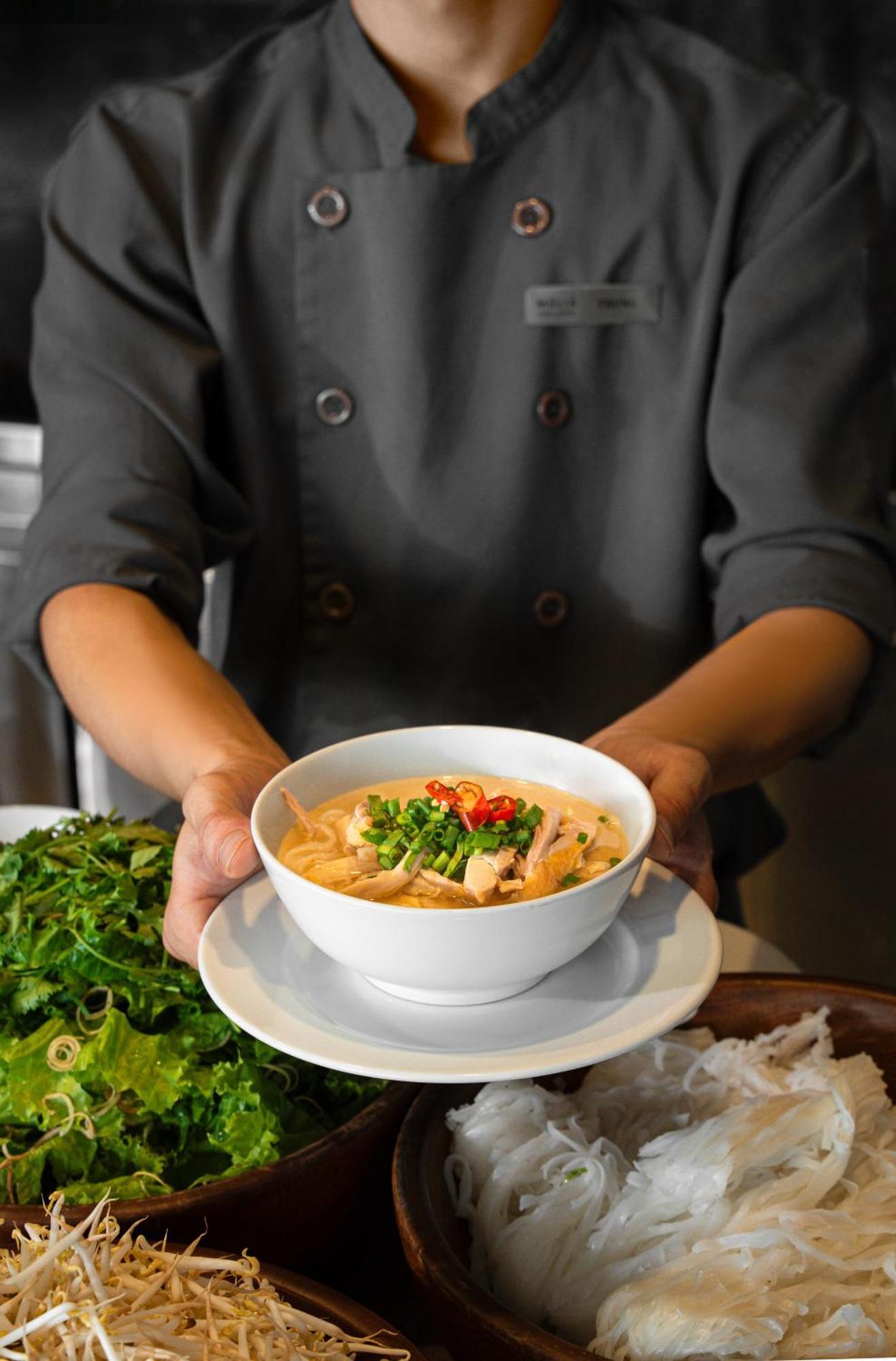 Melia Vinpearl Hue Hotel Luaran gambar A chef holding a bowl of Tom Kha soup